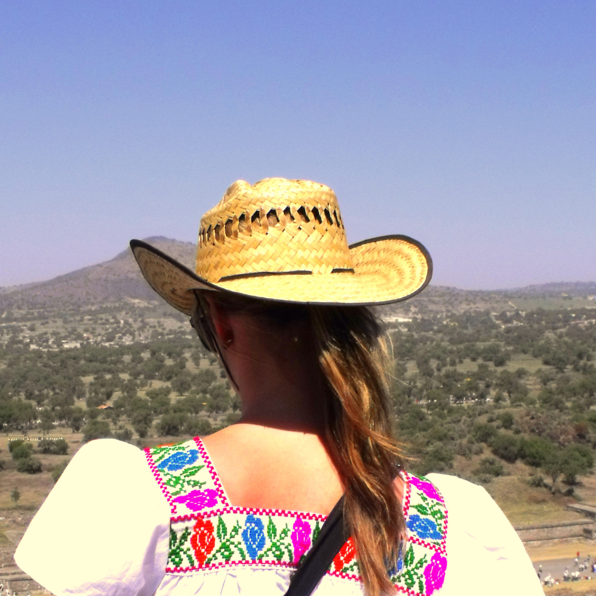 Womans back wearing mexican cloth with hat