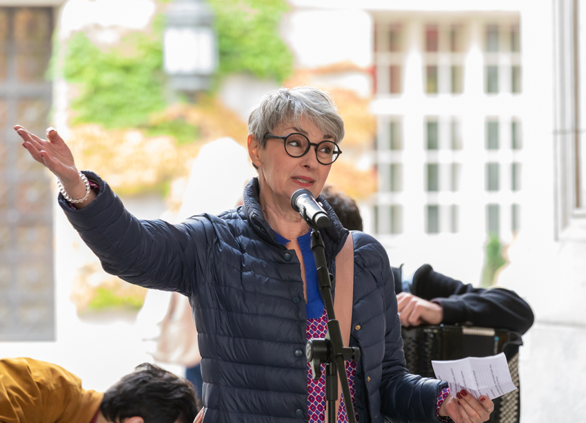 Nirit speaks at the microphone during a lecture